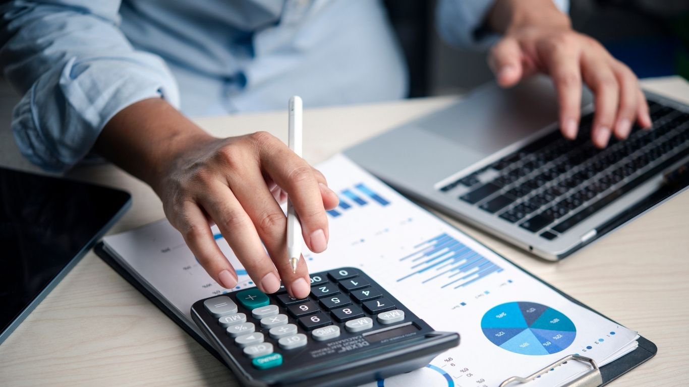A warehouse accountant reviewing financial charts to calculate the useful life of assets.